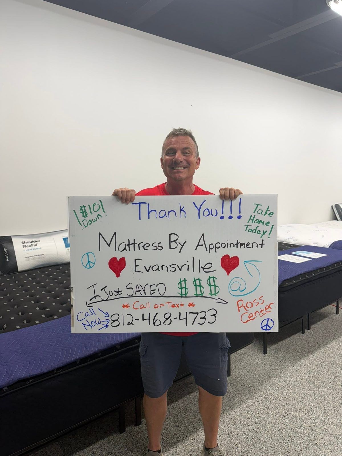 Customer in a red shirt in the showroom holding a handwritten thank-you sign