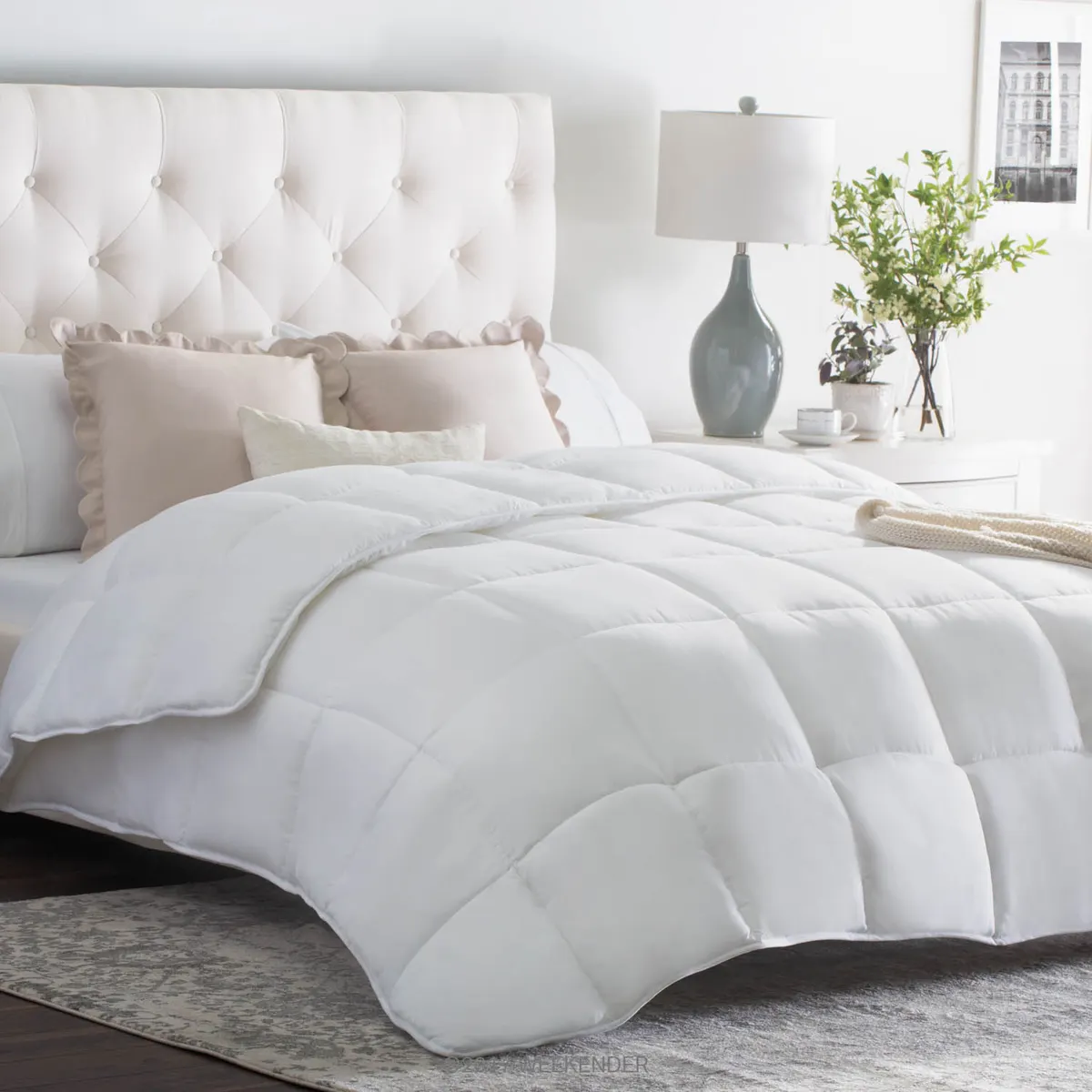 White box-stitched down-alternative comforter on a bed with a tufted headboard
