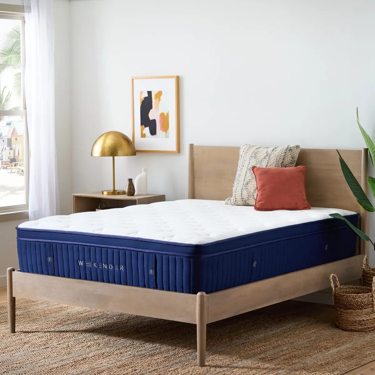 Weekender Euro Top hybrid mattress with a blue sidewall on a wood bed in a bright bedroom