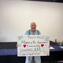 Customer holding a handwritten thank-you sign in the showroom